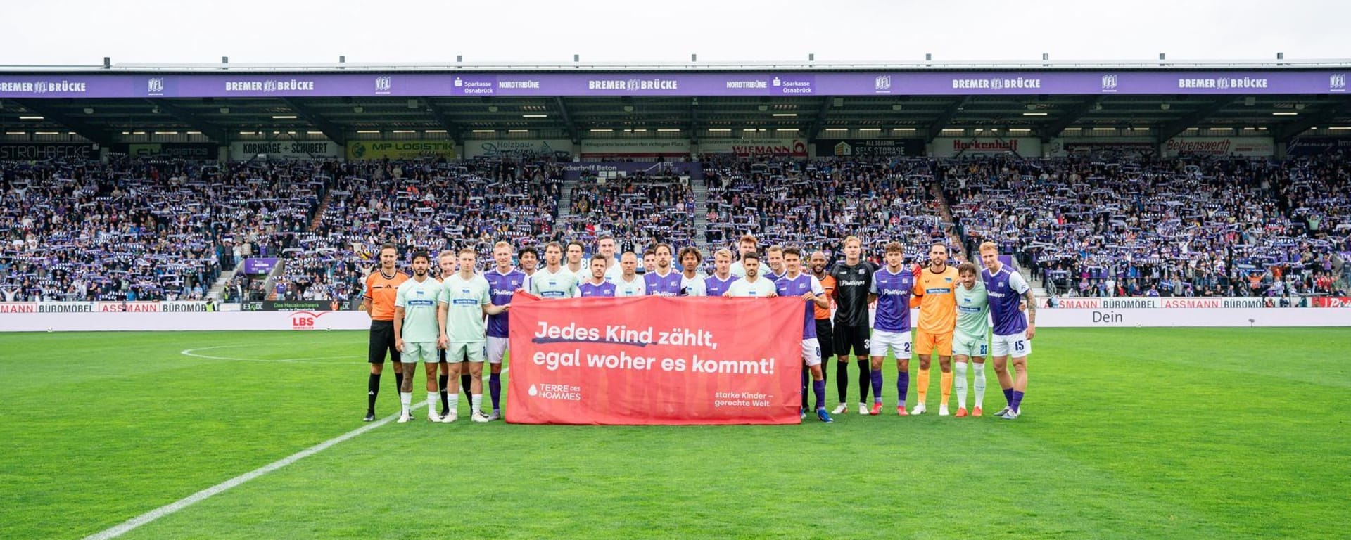 VfL Osnabrück und Hertha BSC halten Banner von Terre des Hommes beim Aktionsspieltag