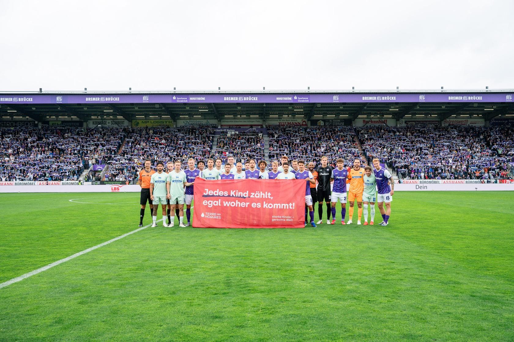 VfL Osnabrück und Hertha BSC halten Banner von Terre des Hommes beim Aktionsspieltag